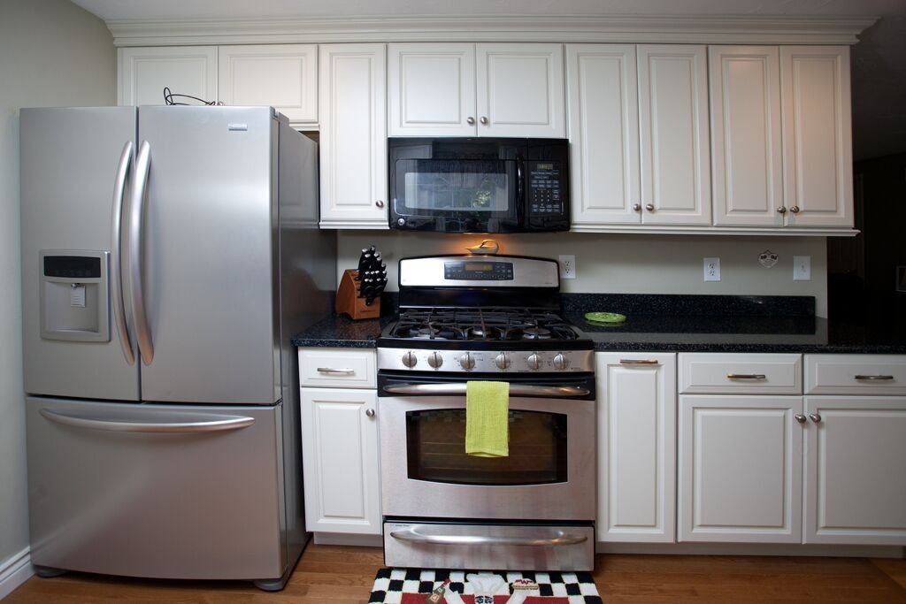 A kitchen with stainless steel appliances and white cabinets