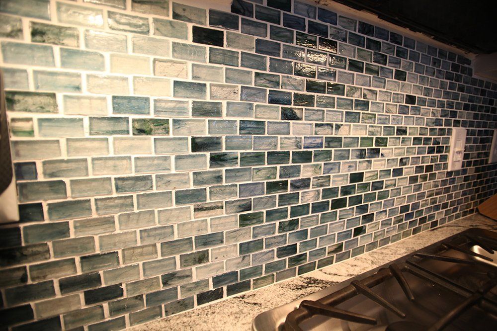 A kitchen with a brick wall and a stove top oven.