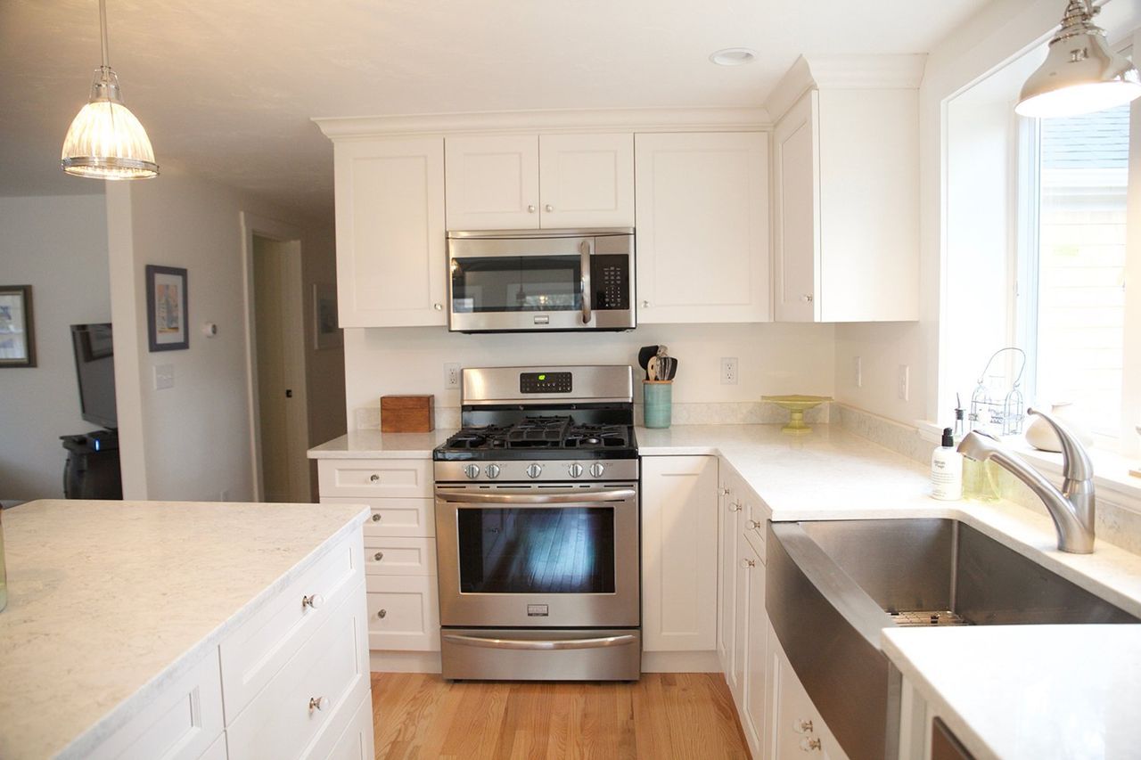 A kitchen with stainless steel appliances and white cabinets