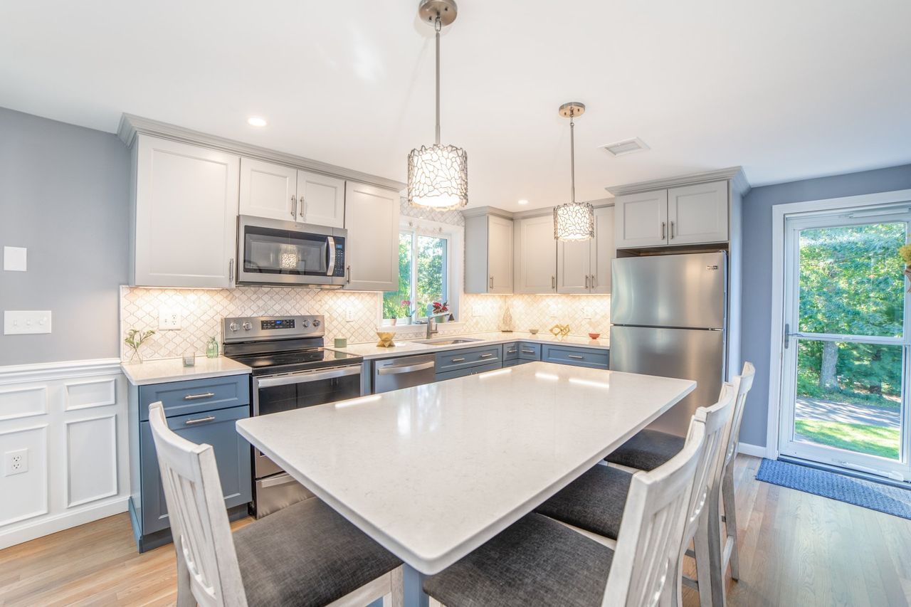 A kitchen with a table and chairs and a refrigerator.