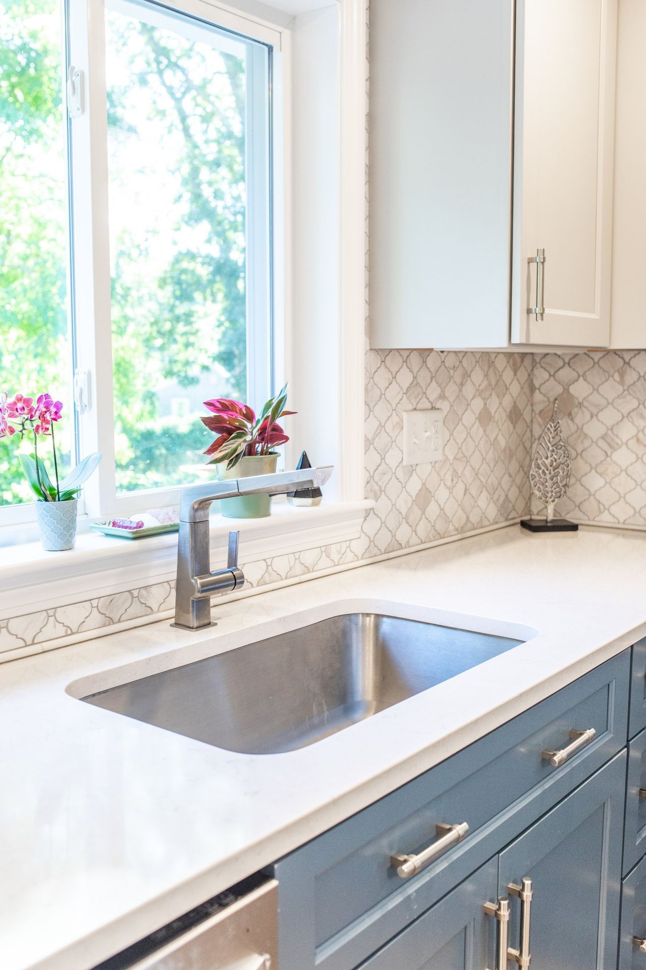 A kitchen with a stainless steel sink and a window.