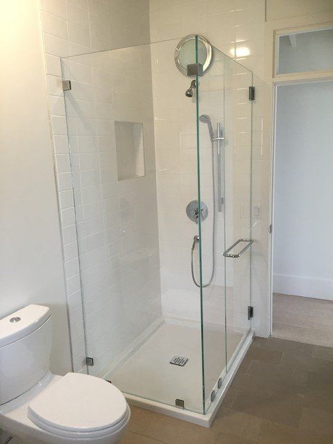 A bathroom with a toilet and a shower stall with a glass door.