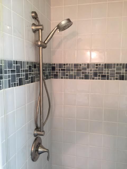 There is a shower head in the corner of the shower.
