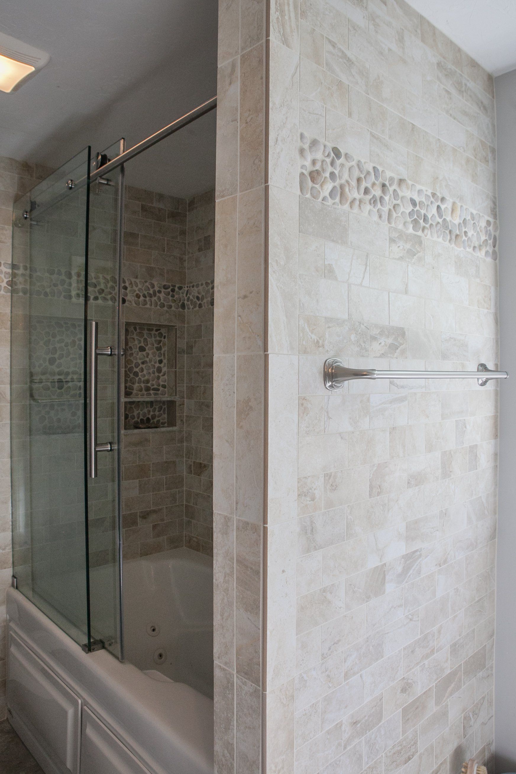 A bathroom with a tub and a shower with a glass door.