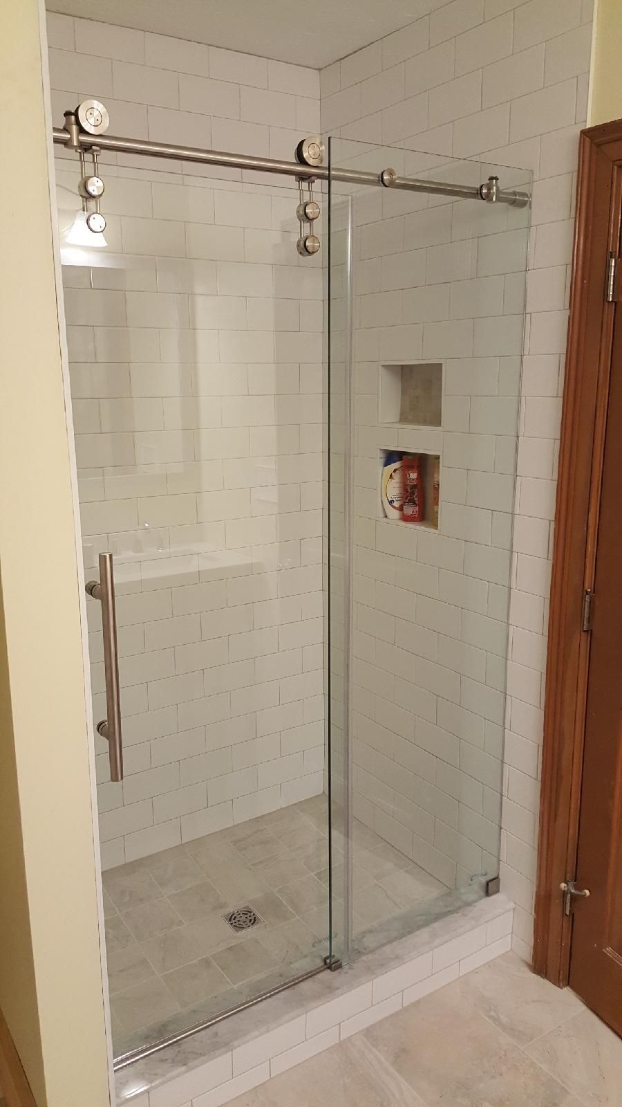 A bathroom with a sliding glass shower door.