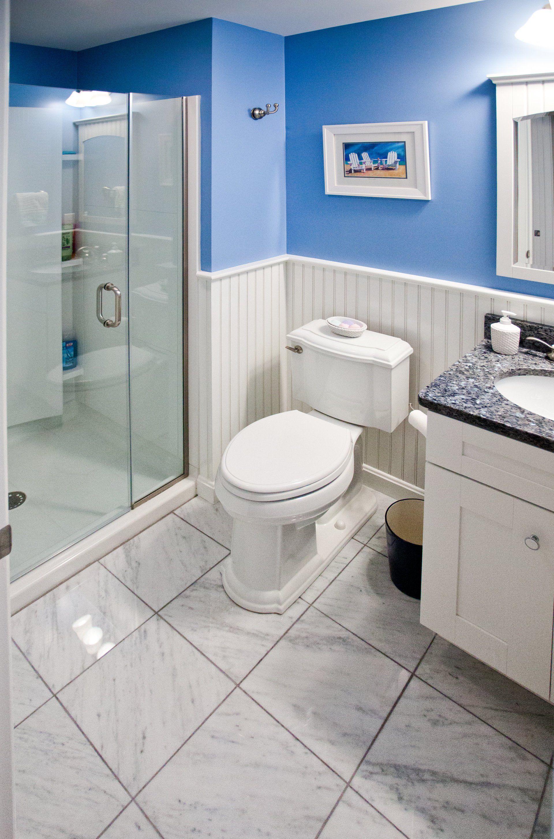 A bathroom with a toilet , sink and shower.