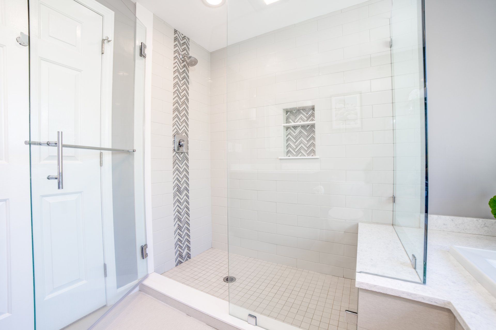 A bathroom with a walk in shower and a glass door.
