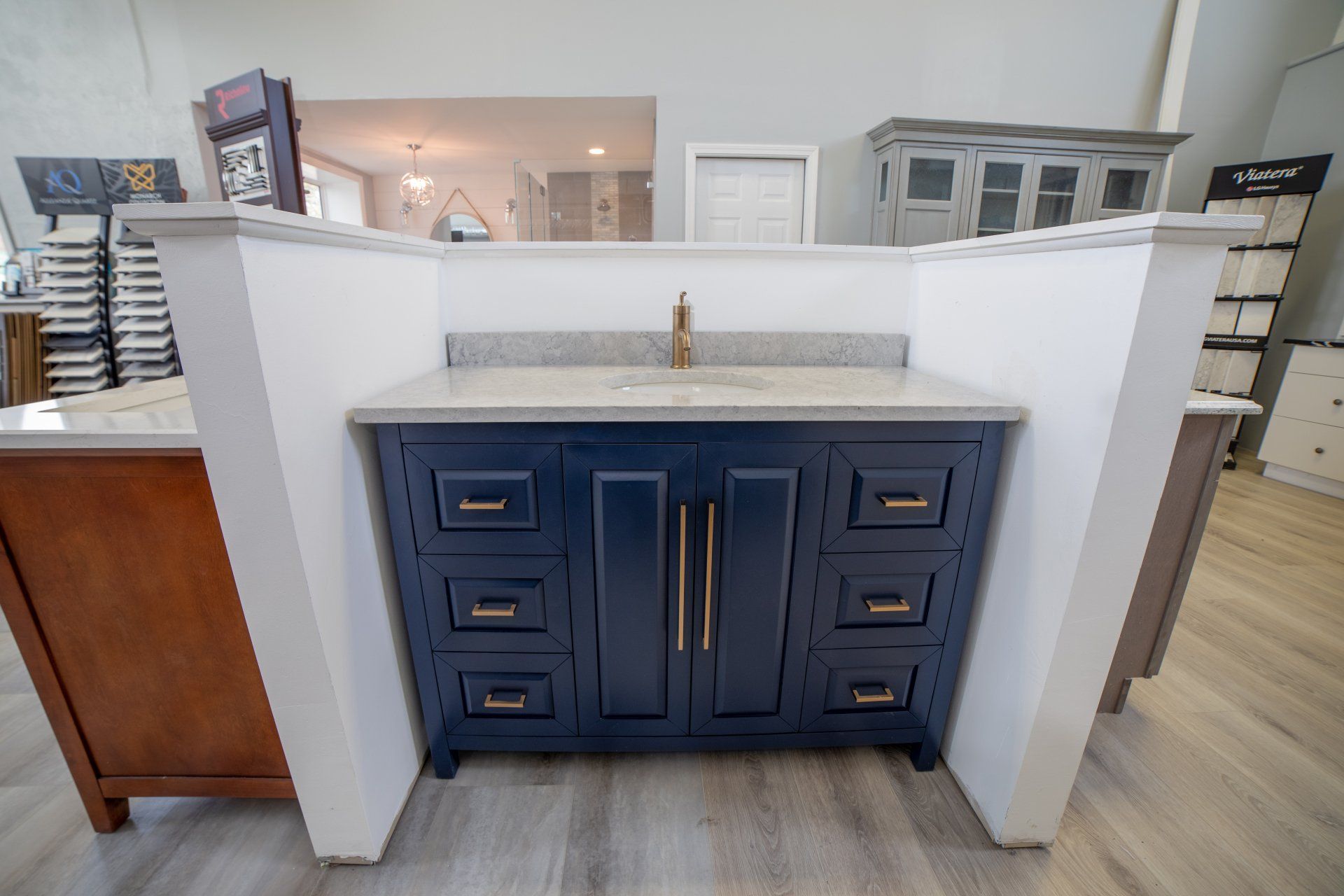 A bathroom vanity with a sink and drawers in a showroom.