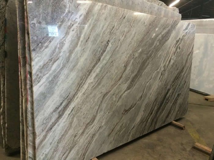 A large slab of marble is sitting on a wooden pallet in a warehouse.