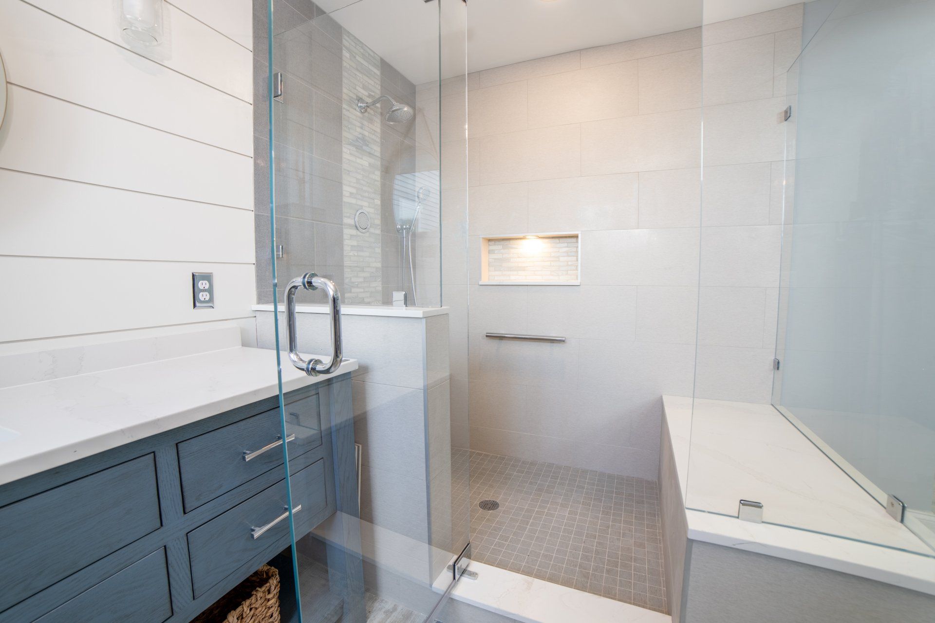 A bathroom with a walk in shower and a sink.