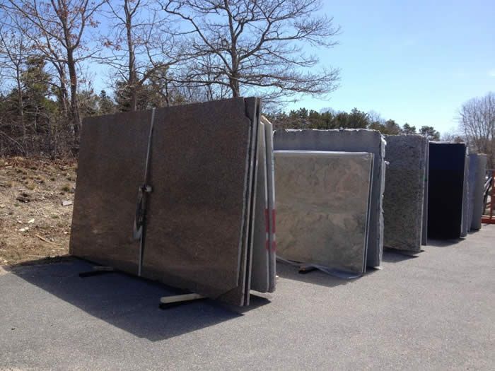 A row of granite slabs are lined up in a parking lot