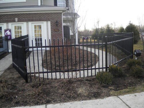A brick house with a black fence in front of it