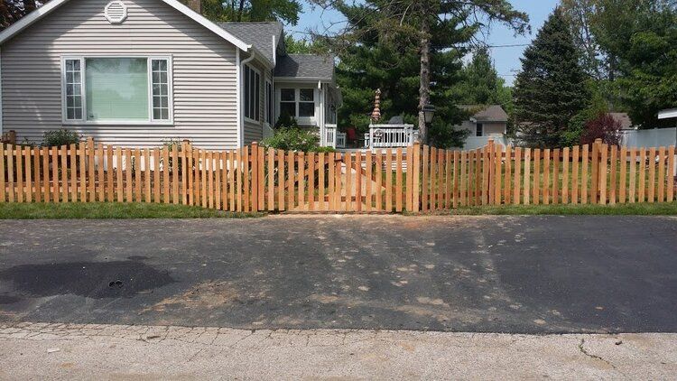 A house with a wooden picket fence in front of it