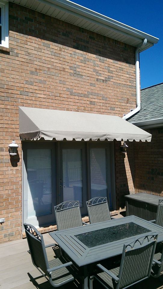 A patio with a table and chairs under an awning.
