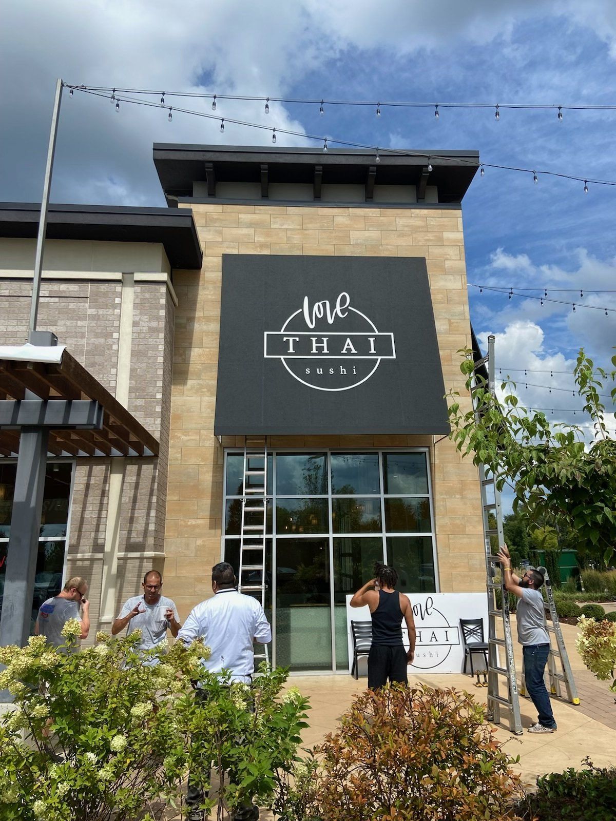 A group of people are working on the front of a building.