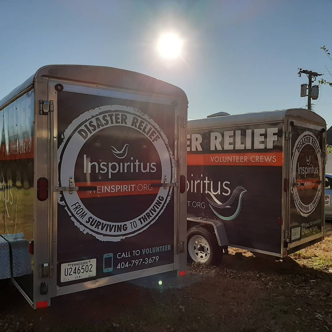 Two trailers are parked next to each other in a parking lot.