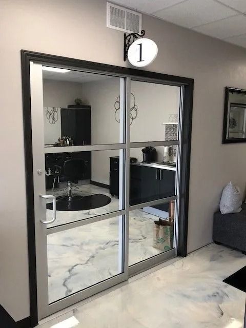 Room entrance with glass doors, number "1" sign. Interior: hair styling station visible. White, gray tones.