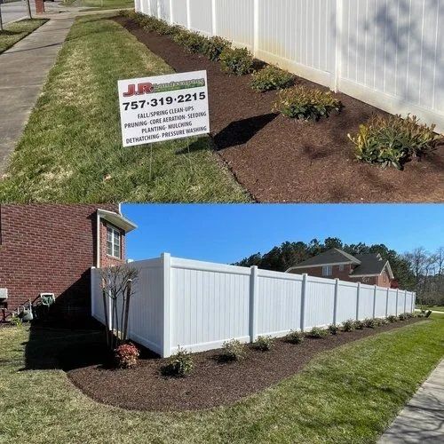 White vinyl fence installation with fresh mulch and landscaping in a suburban yard; yard sign in foreground