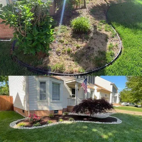 Landscape beds around a house with mulch, shrubs, grass, and curved stone edging in a sunny yard