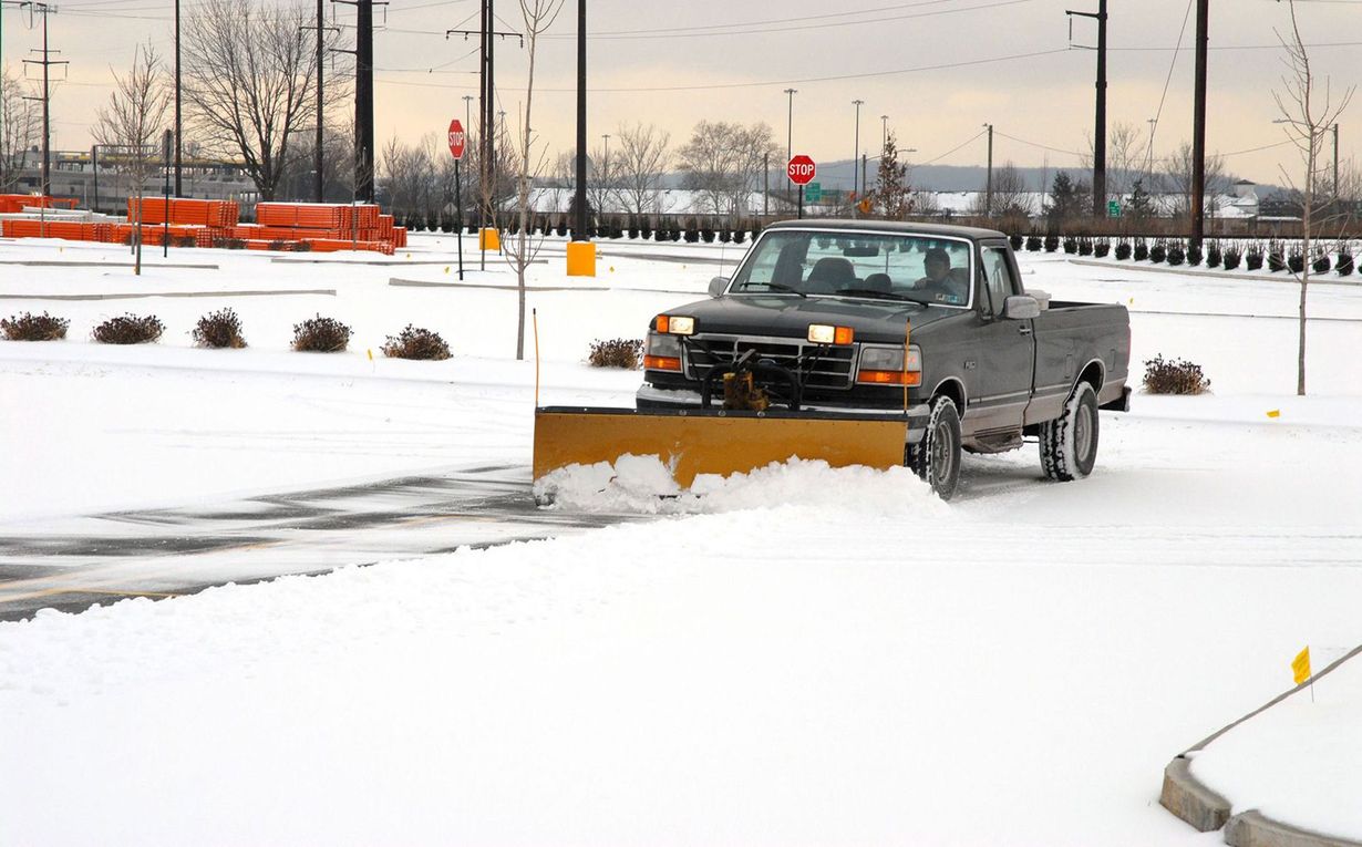 Pickup truck plowing snow in a parking lot