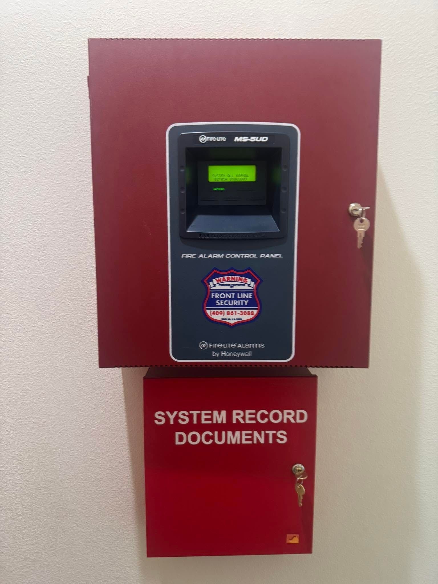 Wall-mounted time clock above a red cabinet labeled “SYSTEM RECORD DOCUMENTS”