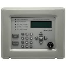 Honeywell security keypad with buttons and display on a gray wall panel