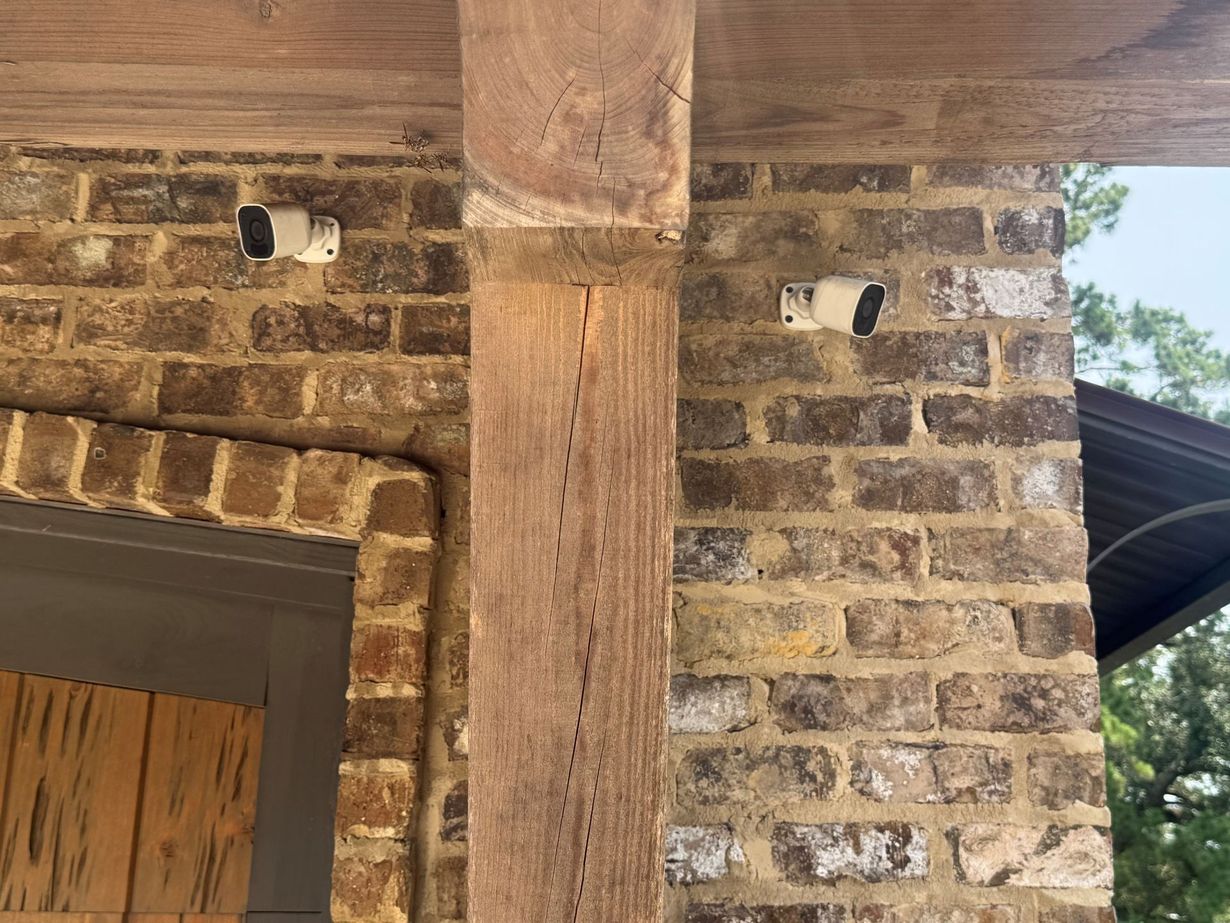 Security cameras mounted on a wall, aimed outward near a building corner.