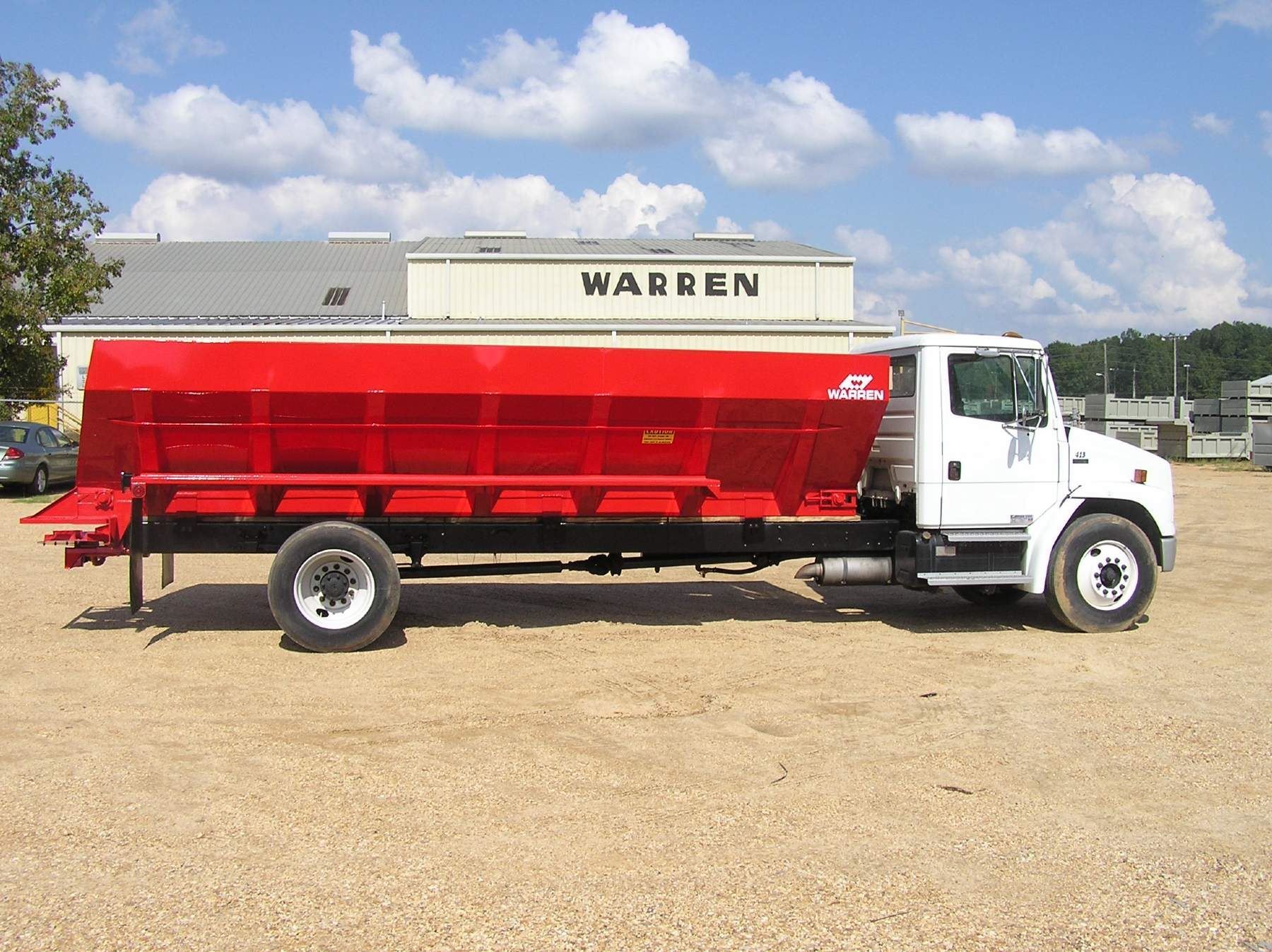 A warren truck is parked in front of a building
