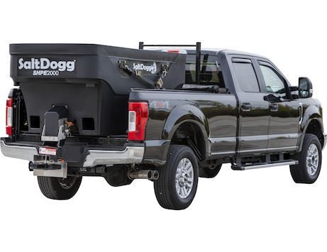A black pickup truck with a salt dogg spreader attached to the bed.