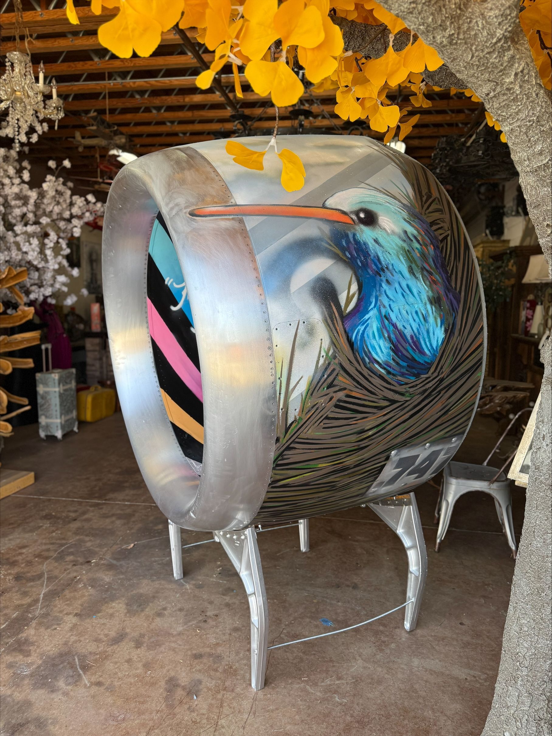A sculpture of a bird is painted on a metal object.
