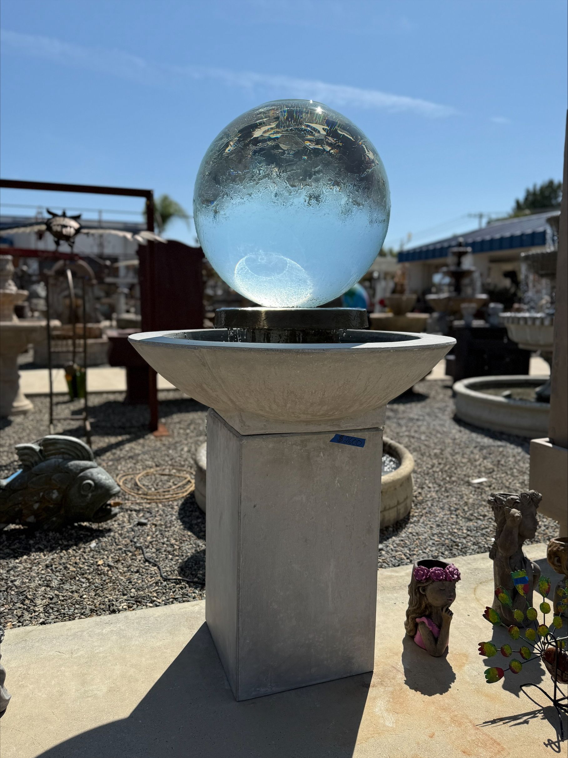 A fountain with a clear glass ball in it