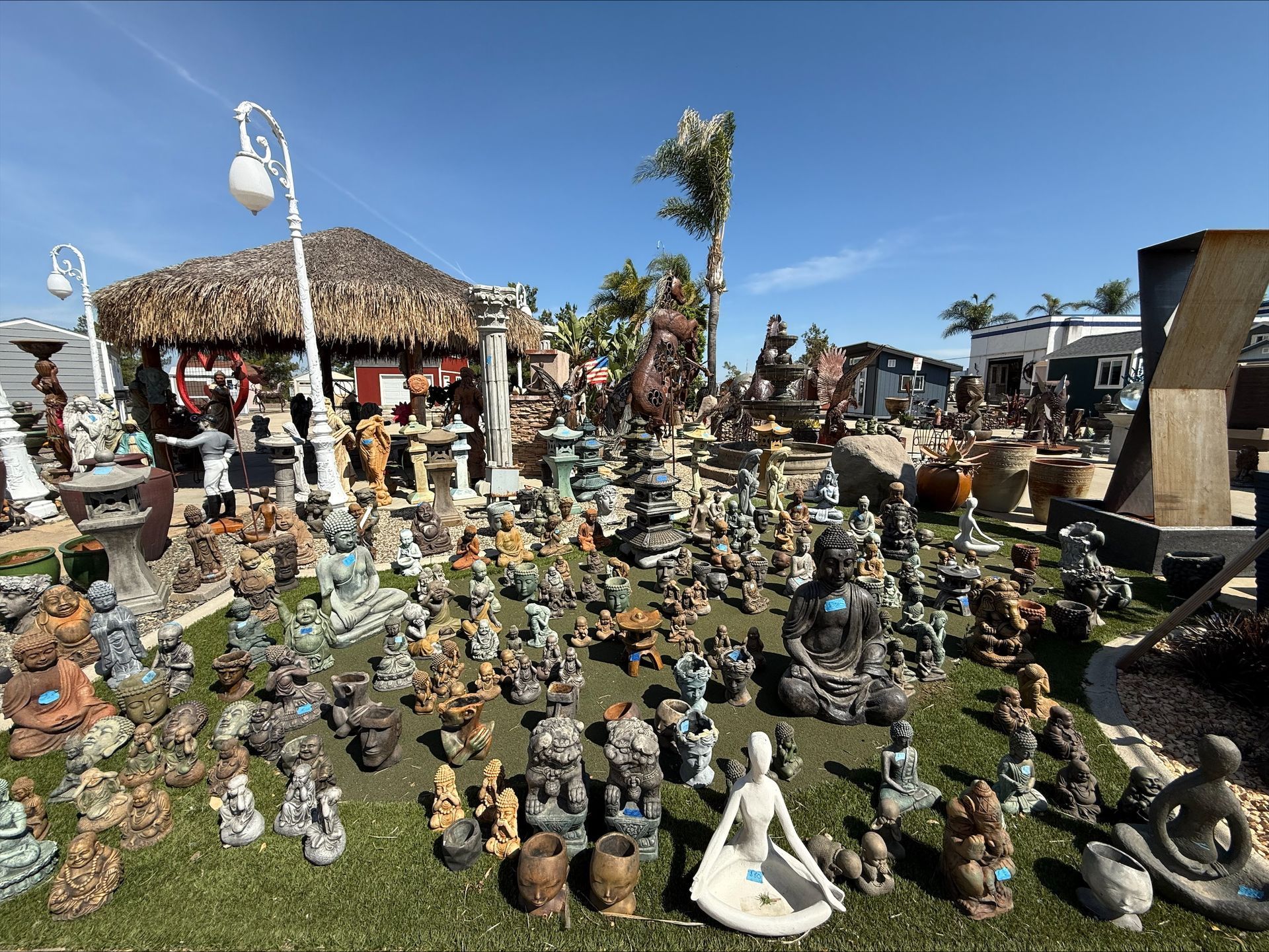 A bunch of statues are sitting on top of a lush green field.
