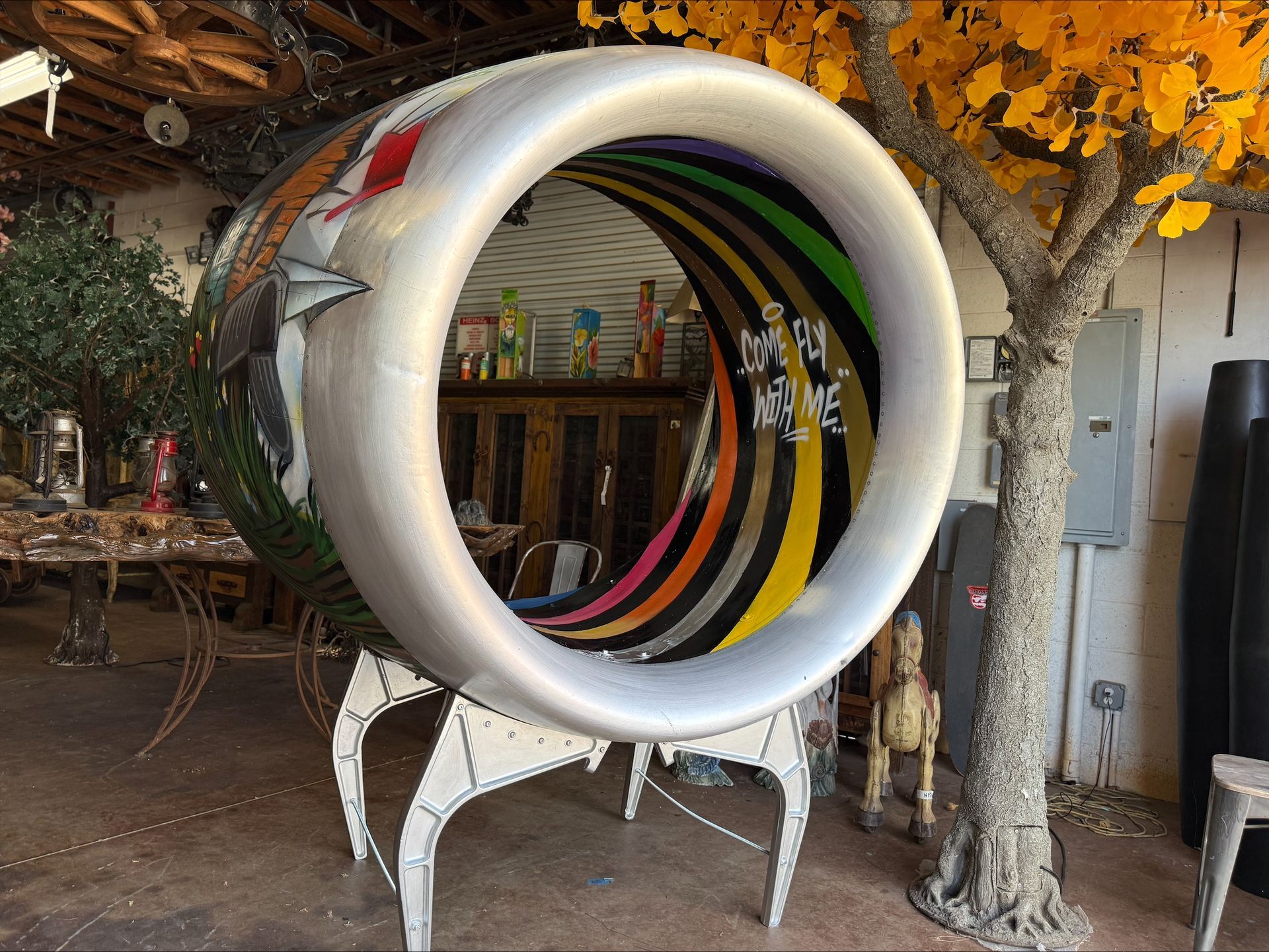 A sculpture of an airplane engine with a tree in the background