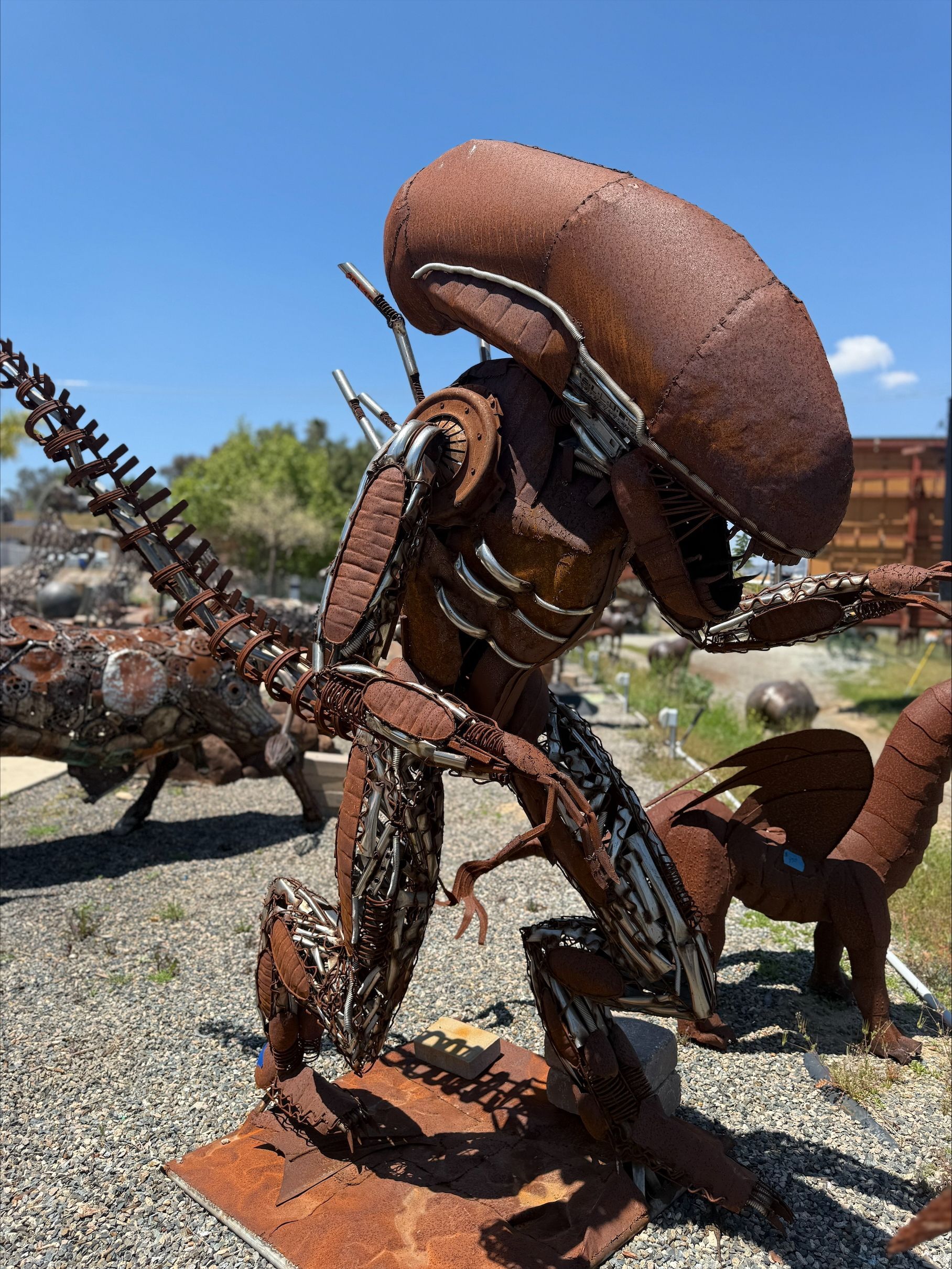 A statue of an alien made out of rusty metal