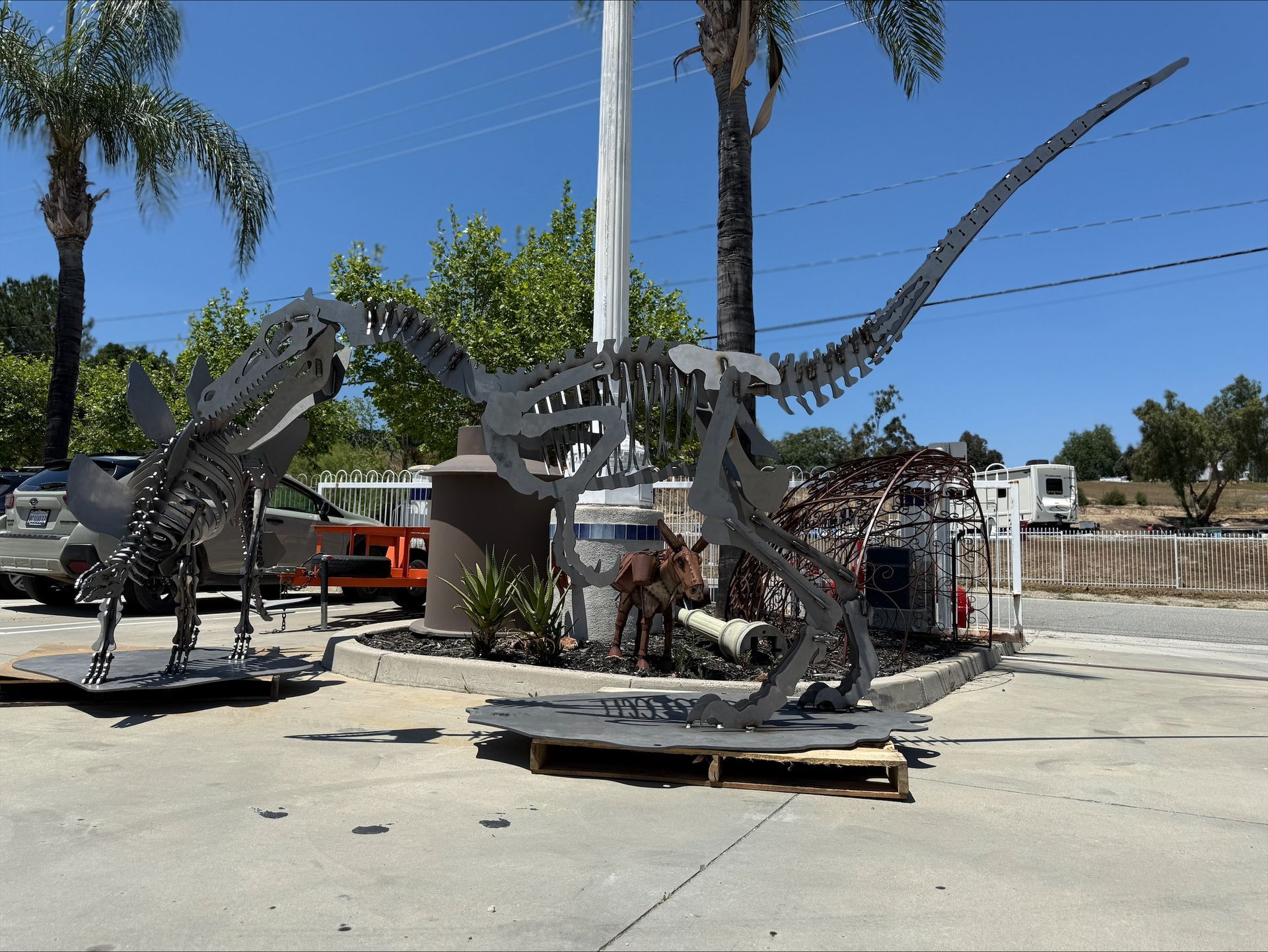 A statue of a dinosaur is sitting on a pallet in a parking lot