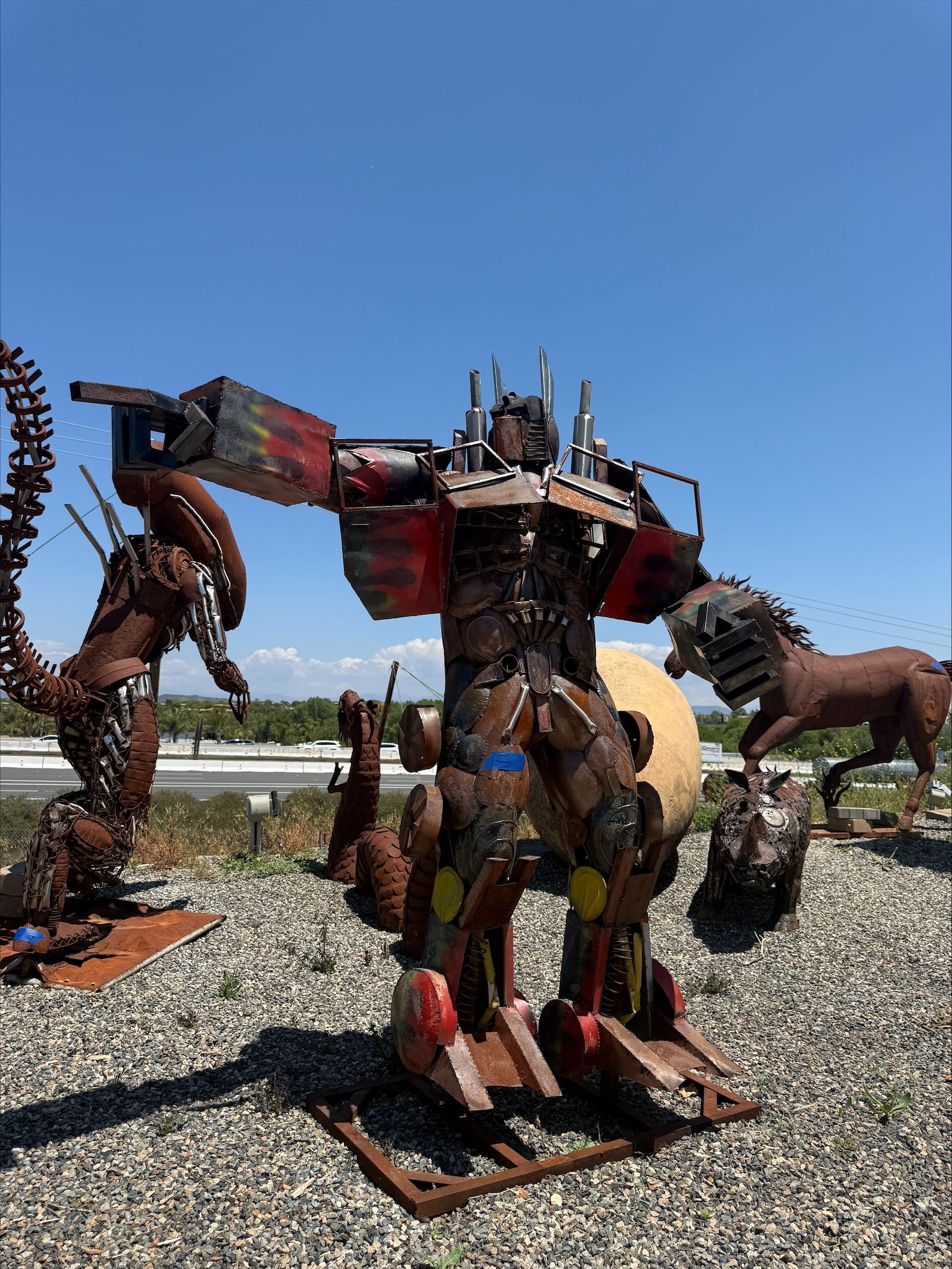 A statue of a robot standing next to a horse.