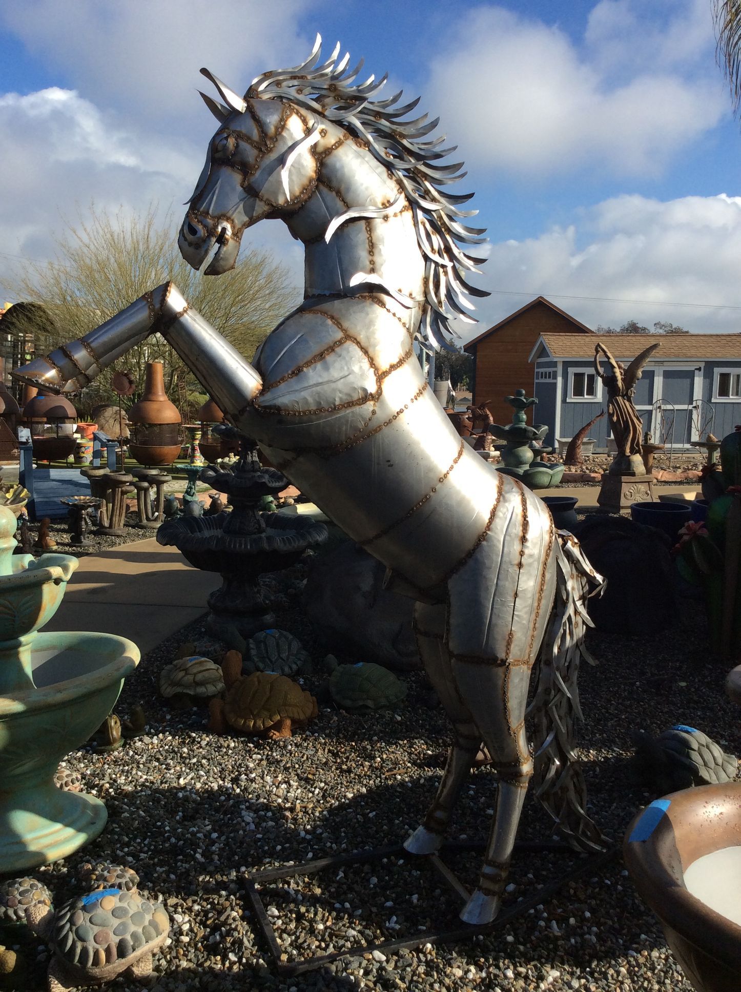 A metal statue of a horse standing on its hind legs