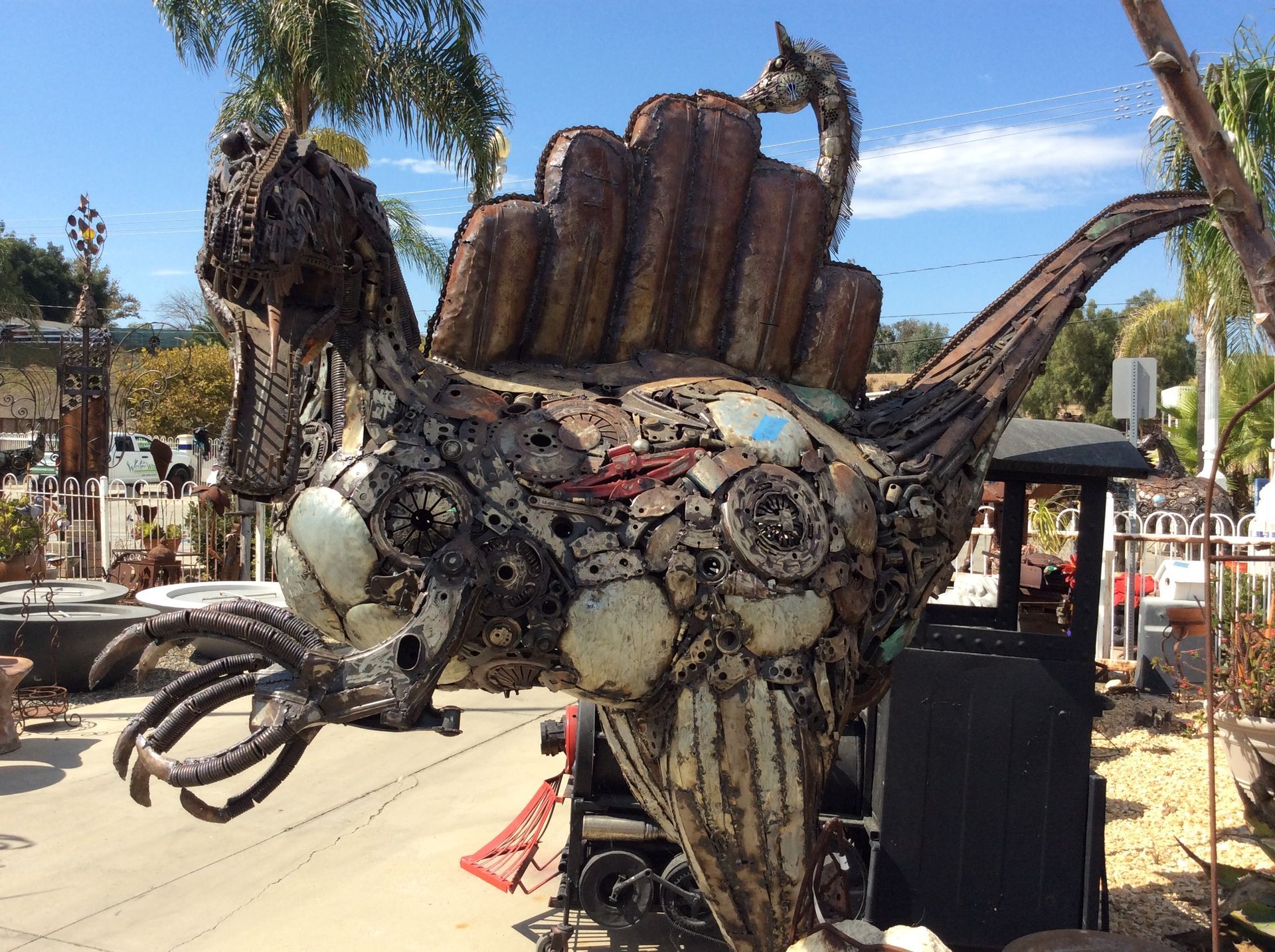 A statue of a dinosaur made out of scrap metal