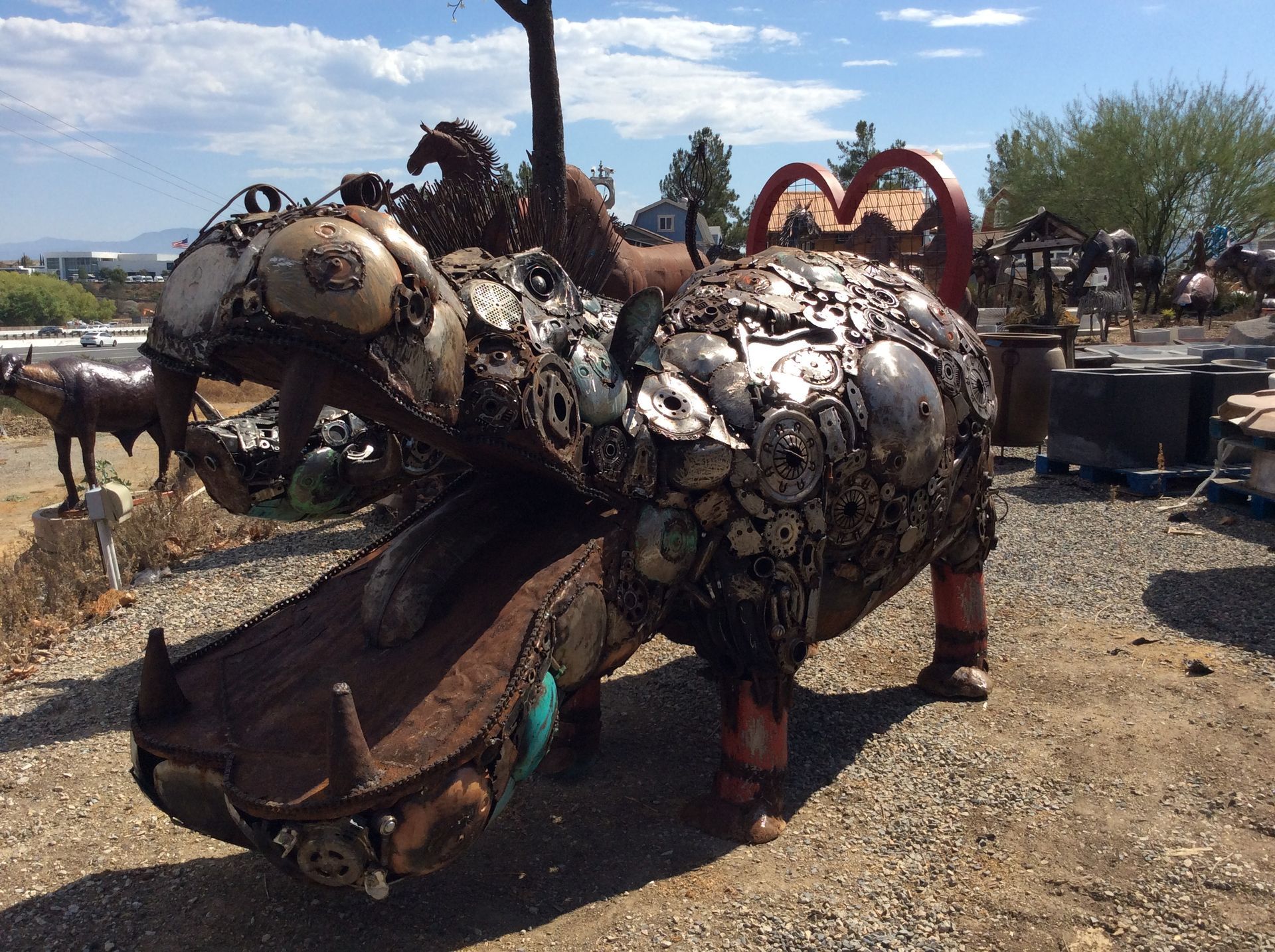 A metal sculpture of a hippopotamus with its mouth open