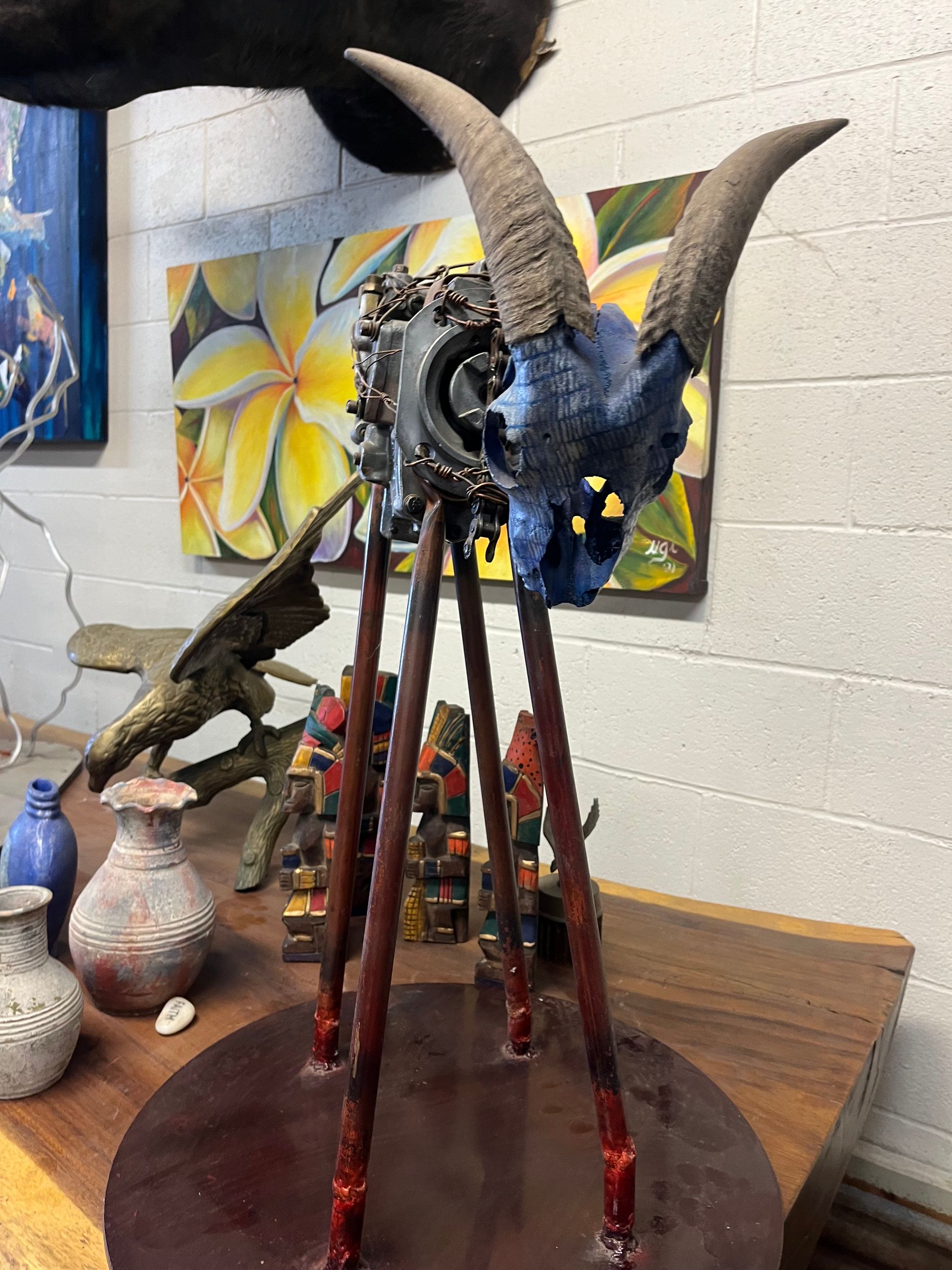 A statue of a goat 's skull is sitting on a wooden table