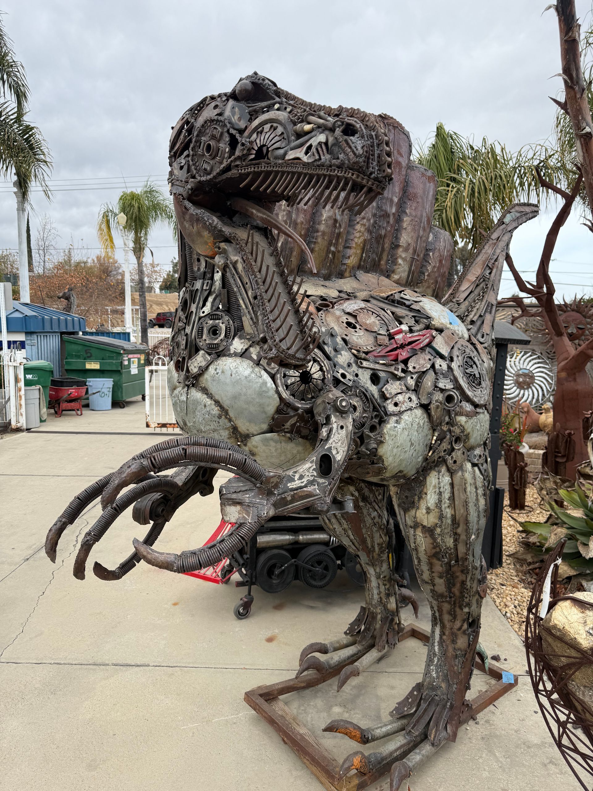 A statue of a dinosaur made out of scrap metal