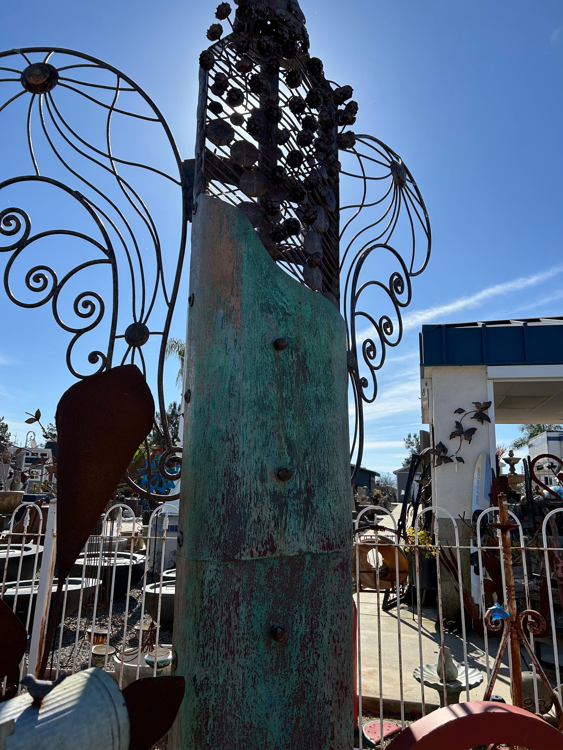 A statue of an angel with wings and a blue sky in the background