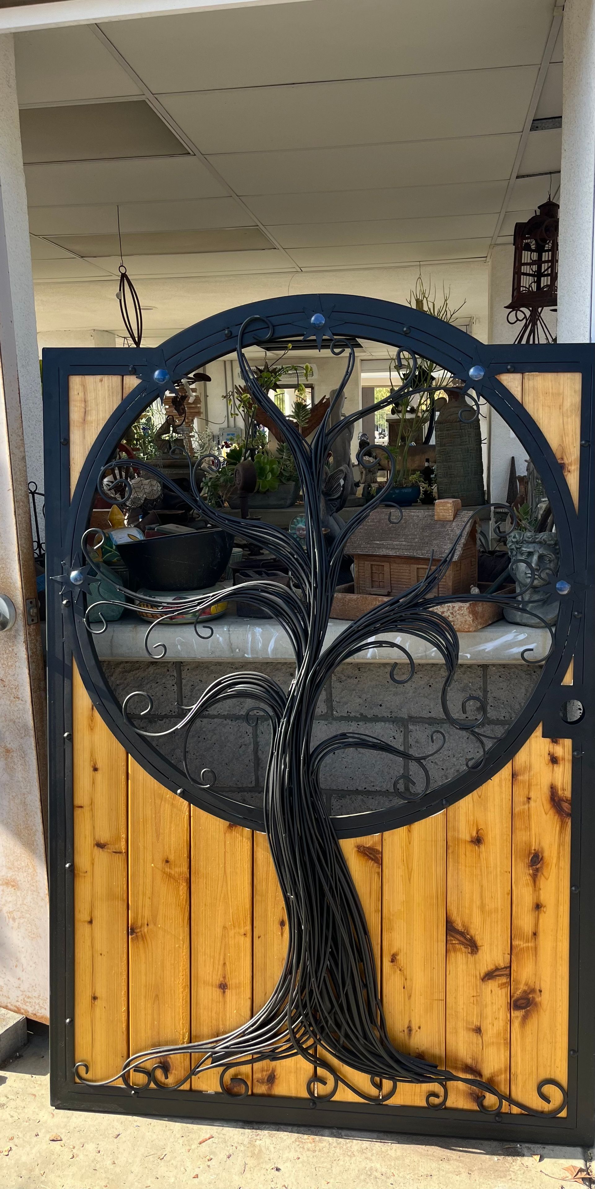 A wrought iron gate with a tree in the middle of it.