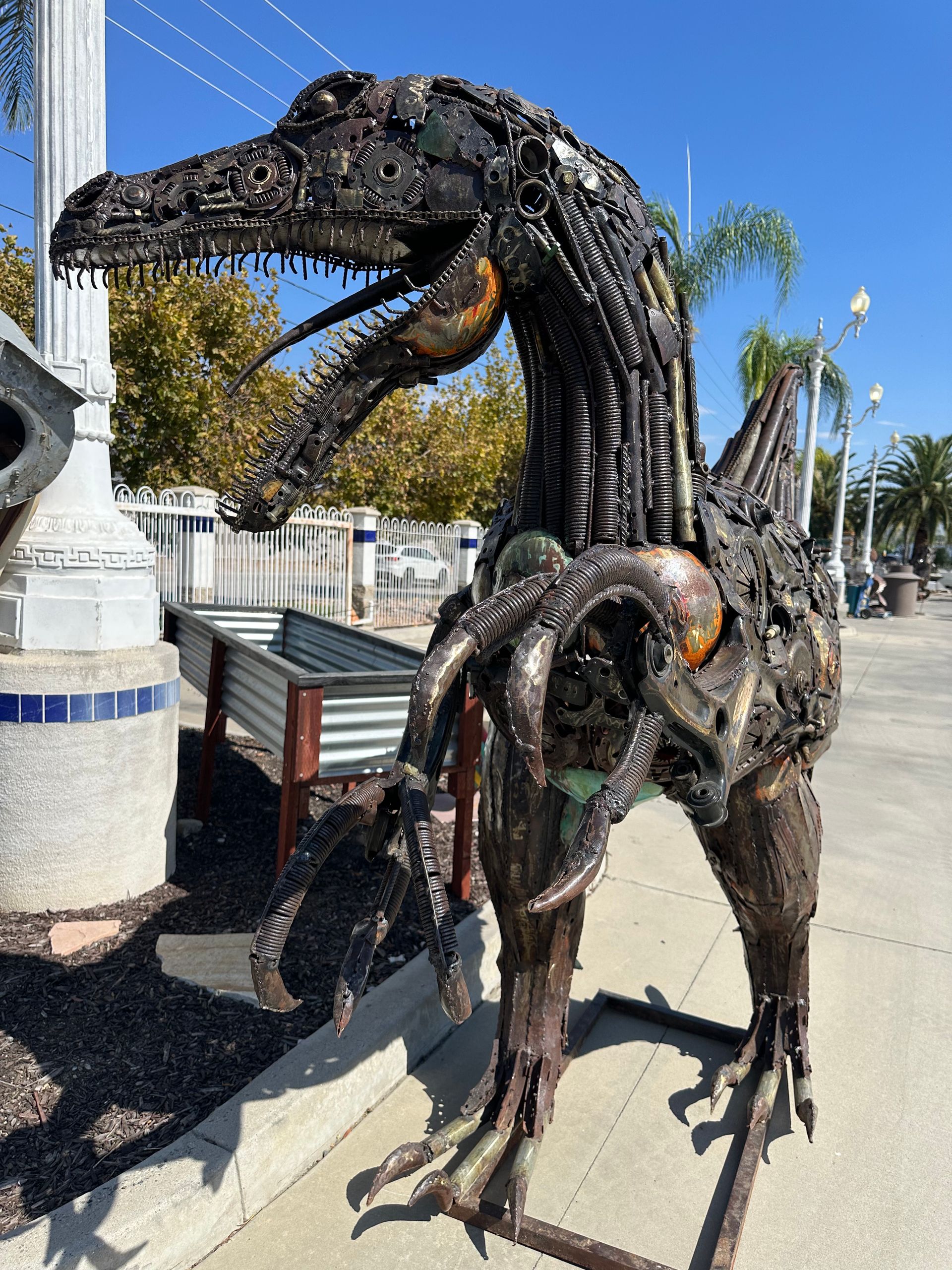 A statue of a dinosaur made out of scrap metal