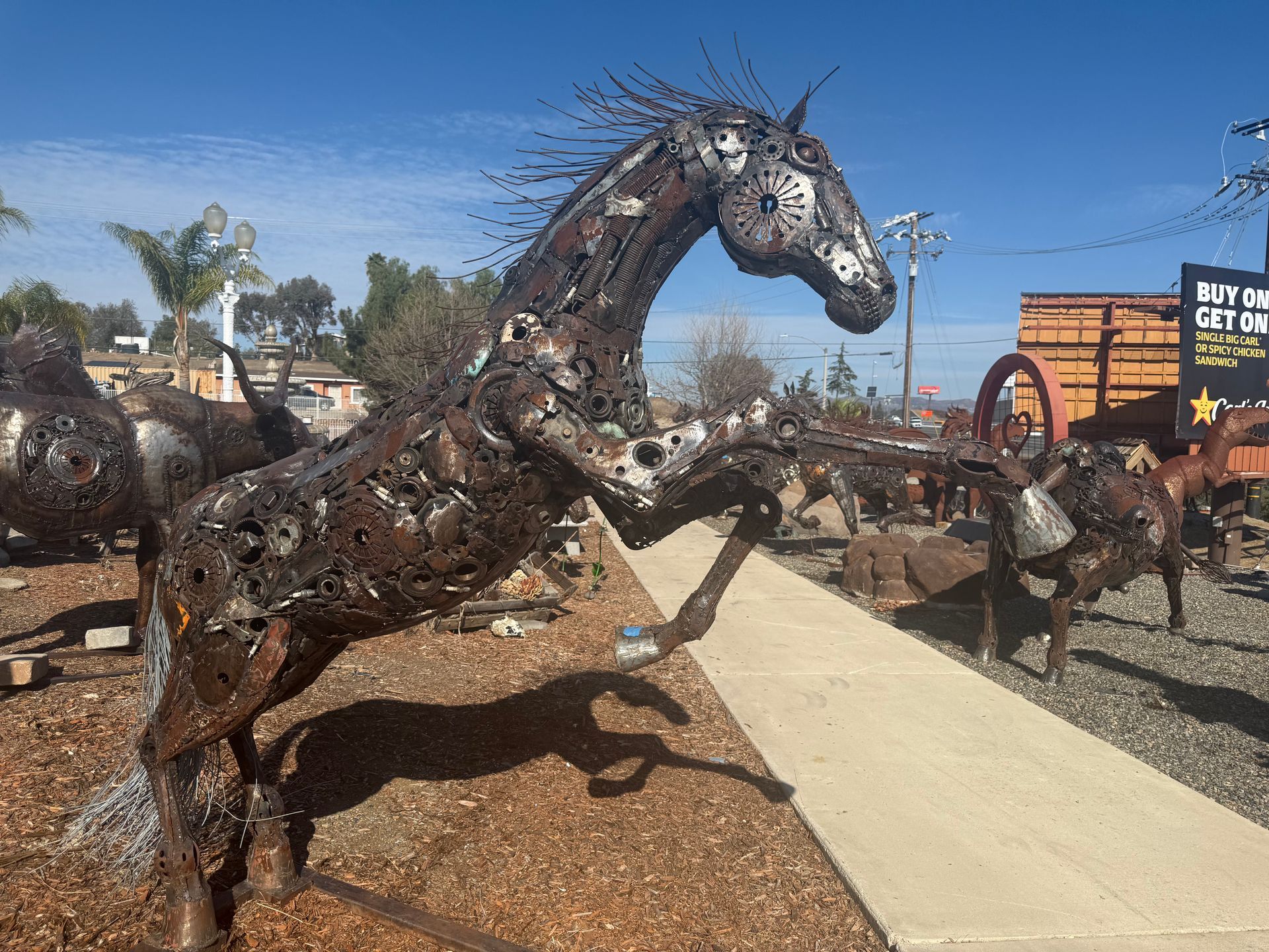 A statue of a horse made out of metal is standing on its hind legs.
