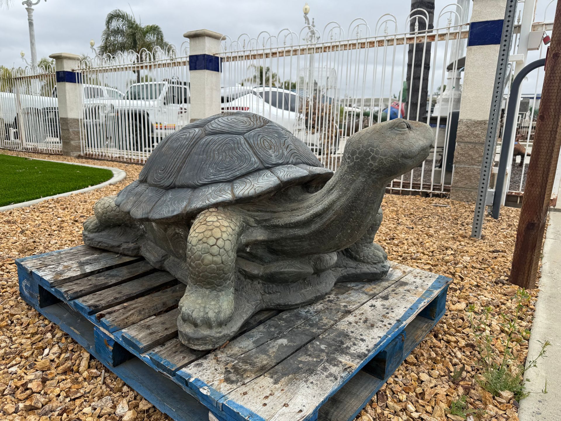A statue of a turtle is sitting on top of a wooden pallet.