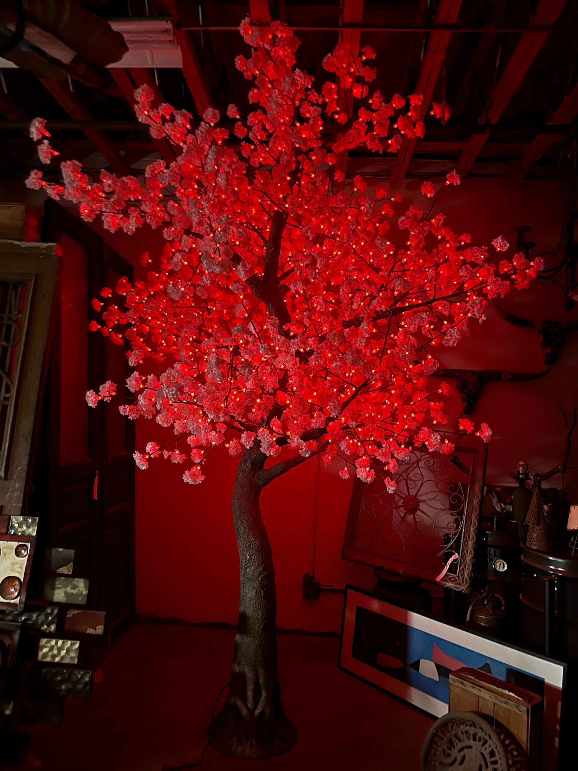 A cherry blossom tree with red lights on it