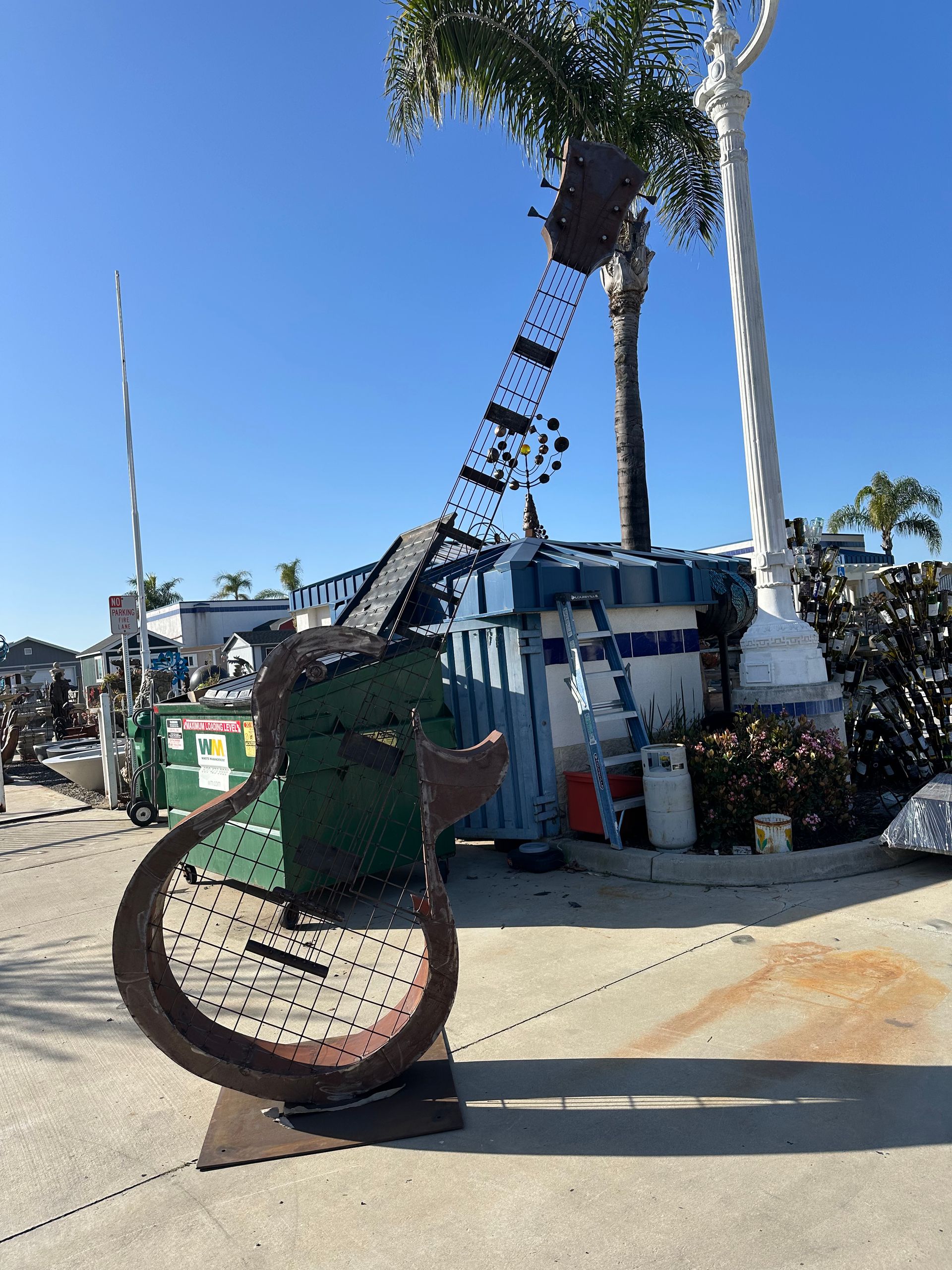 A sculpture of a guitar is sitting on the sidewalk