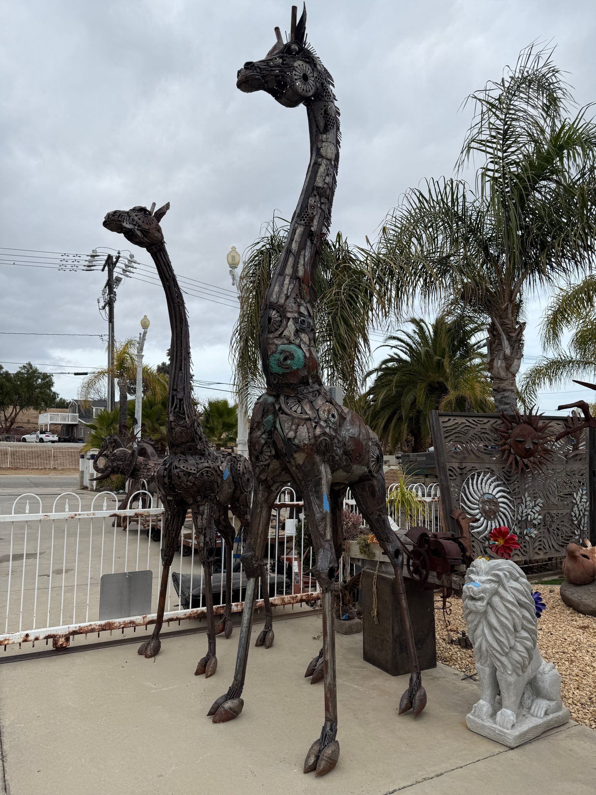 A statue of a giraffe is standing next to a statue of a lion.