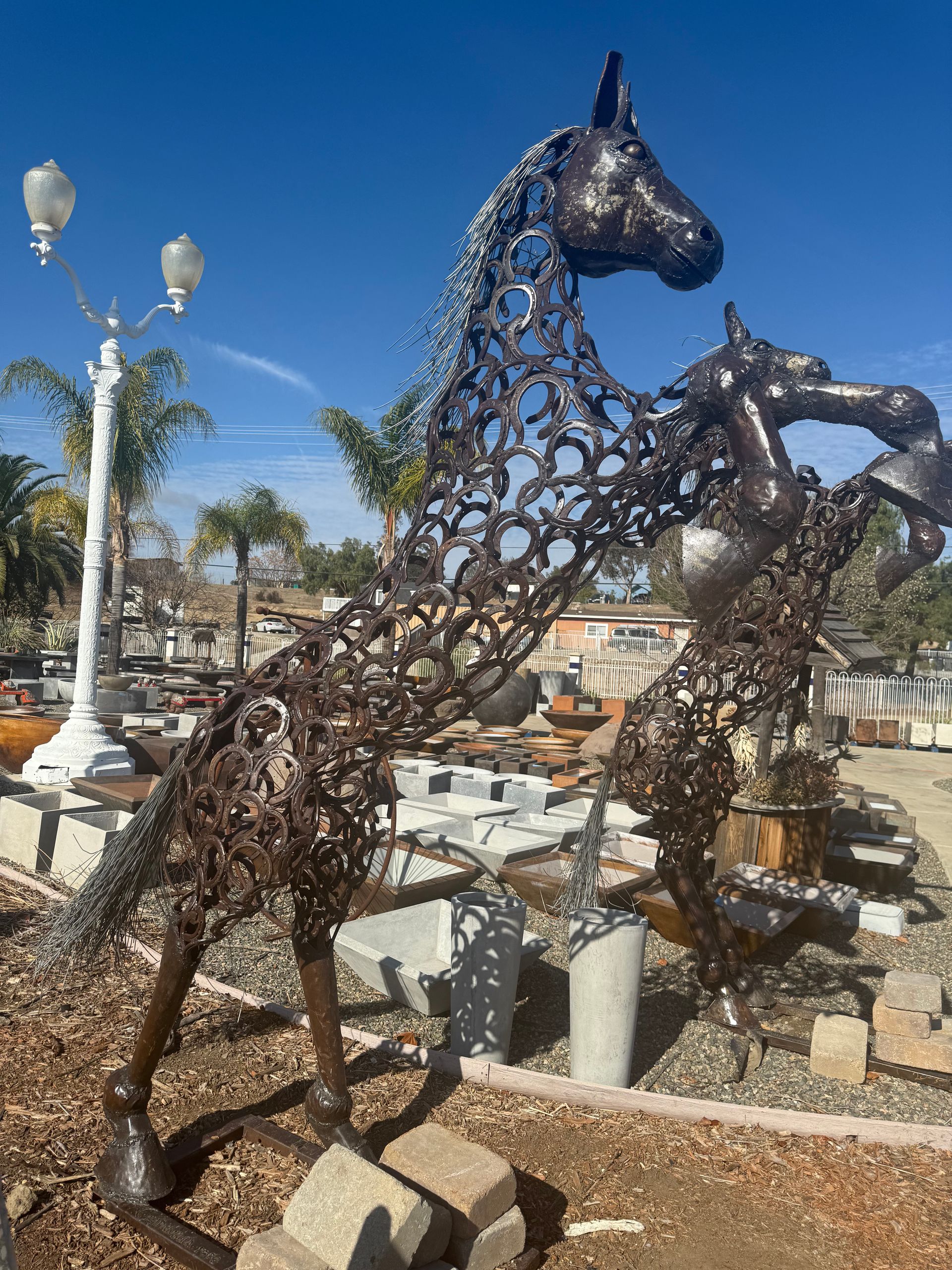 A statue of two horses standing next to each other in a park.